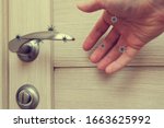 Small photo of human life through which germs and viruses spread, door handle in an apartment in a room or house with hand and finger, the concept of germs sitting on the door handle