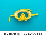 flat lay shot of yellow diving mask over turquoise blue background. minimalist photo of dive mask with central composition