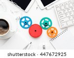 workflow and teamwork concepts with colorful gears different gadgets and office stationery on the white office table
