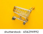 close-up of shopping trolley on yellow background with some copy space