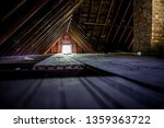 Old attic space with roof rafters and a window, shallow focus on wooden floor
