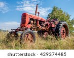 Old Red Rusty Tractor In A Field