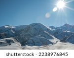 beautiful glare of the sun illuminates snowcapped mountains. panoramic view. Winter. beautiful clear blue sky in daylight. impressive view of the mountain peaks