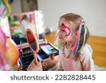 Small photo of Children face painting. Artist painting little preschooler girl like unicorn on a birthday party. Creative activities for kids