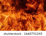 Small photo of Abstract red fire natural texture with flames. Beautiful dangerous firestorm abstract background. Atmospheric dispersion, defocus (soft focus), motion blur from fire, high temperature from flames.