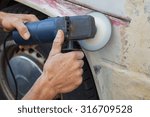 Small photo of man rub away rust from an old car with a grinder machine