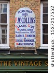 Small photo of LONDON - OCTOBER 6, 2019. An antique enamel sign daing from 1835 for an ironmonger over The Vintage Showroom, a clothes archive in Earlham Street, Covent Garden, London, UK.