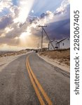 Small photo of Sunlight through the storm clouds over roadway along Chapin Beach in Cape Cod, Massachusetts.