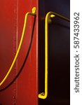 Small photo of An abstract photograph of a bright yellow rail against a deep red old train