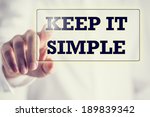 Keep It Simple in a navigation bar on a virtual screen with a businessman touching it to activate it from behind conceptual of simplicity, clarity and easy understanding in business and in life.