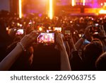 People with mobile phones record a music concert
