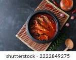 Small photo of Top view of Sardine fish curry hot and spicy. Kerala masala fish curry with coconut milk. Side dish for rice in India . Asian cuisine Indian food popular in Bengal Goa Sri Lanka.