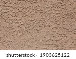 A tan colored abstract stucco background.