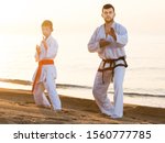 Small photo of Man and boy exercising karate in morning outdoor