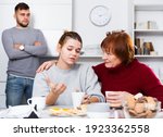 Small photo of Senior woman calming chagrined girl during her quarrel with boyfriend