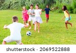 Small photo of Cheerful tween friends gaily spending time together on sunny summer day, playing with ball outdoors..