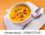 Light healthy carrot cream soup with croutons served in plate. Vegetarian concept. Gastronomic delight..