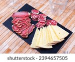 Small photo of On table - snack plate with meat delicate - sliced sausages and morsels of cheese. Thick slices of ham bacon and complement fragrant circles of butifarra sausage, and large cheese slices.