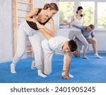 Small photo of Couples self-defense training - a woman learns to seize power against a male attacker