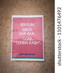 Small photo of Putrajaya, Malaysia - May 12, 2018: laminated pink paper with wording in Bahasa Malaysia asking people to say thank you and smile when getting their items in free market (free items for the needy)