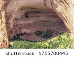 Small photo of View of an ancient Anasazi Indian cave dweller site set in a sandstone cliff face overhang, Arizona showing the stone-built dwellings built into the cave