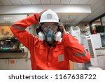       Multi-purpose respirator half mask for toxic gas protection.The man prepare to wear Multi-purpose respirator half mask.                        