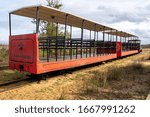 Small photo of Tavira, Portugal - January 23, 2020: The red mini train at Pedras del Rei station departing for Barril beach at Ilha de Tavira lets visitors forgo the 1km walk to Anchor Cemetary