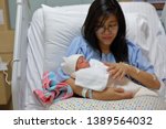 Small photo of mother parenting, mom using hand help a baby newborn belch burping after breastfeeding milk