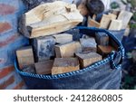 Small photo of Firewood bag. Preparing for a picnic in nature or kindling the furnace. Travel and tourism concept