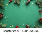 Christmas composition. Christmas decor, pine cones, fir branches and golden confetti on green background. Flat lay, top view, copy space.
