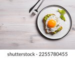 Small photo of Avocado toast with fried egg on wooden table, top view, copy space. Toasted bread with avocado and egg for healthy breakfast.