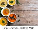 Small photo of Autumn soups. Set of various seasonal vegetable soups and organic ingredients on wooden background, top view, copy space. Homemade colourful seasonal vegan soups.