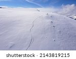 Drone photograph with shapes of ski turns in fresh powder snow	