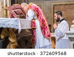 Small photo of ROME, ITALY - CIRCA JANUARY 2016 - A priest saying the traditional extraordinary tridentine latin rite of the Catholic mass in the basilica of St Nicholas in Rome, with the altar servant kneeling