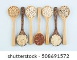 Various varieties of rice and wholegrains in spoon on wooden table background. Wheat, barley, millet, oats, rice, coarse grain, sorghum, lotus seed.