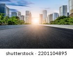 Straight asphalt road and modern city skyline with buildings in Guangzhou at sunset, China.
