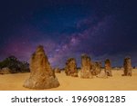 Starry sky above pillars of fossil plant remains The Pinnacles in Nambung National Park in Western Australia with golden yellow ornaments on the foreground against the sky of the Milky Way galaxy