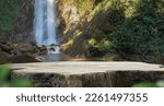 Small photo of wood table top podium in outdoors waterfall green lush tropical forest nature background.organic healthy natural product present placement pedestal counter display,website banner cover jungle concept.