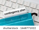 Small photo of contingency plan is on a label of a blue hanging file. In the background a computer keyboard