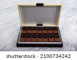 Small photo of Madlen Chocolate, Square Chocolate Pack on marble floor. Milk and dark square chocolate Madlen is designed geometrically. Candy Day or any festival celebration.