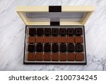Small photo of Madlen Chocolate, Square Chocolate Pack on marble floor. Milk and dark square chocolate Madlen is designed geometrically. Candy Day or any festival celebration.