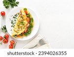 Small photo of Stuffed omelette with tomatoes and spinach on light background with copy space. Top view, flat lay