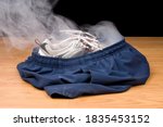Small photo of A pair of smoking shoes and shorts remain as the illusion insinuates that a person has vanished right out of their clothing.