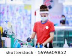 Small photo of female supermarket cashier in medical protective mask and face shield working at supermarket. covid-19 spreading outbreak