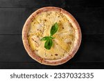 Small photo of Browned baked cheese pizza quattro formaggi garnished with basil