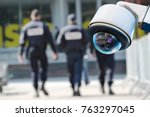 security CCTV camera or surveillance system with military on blurry background