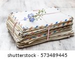 Stack of vintage love letters and forget me not flowers.