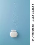 Small photo of Dental floss case on blue background. Daily dental care. Advertising concept