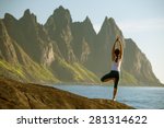 woman is practicing yoga between mountains in Norway