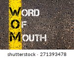 Acronym WOM as Word Of Mouth. Yellow paint line on the road against asphalt background. Conceptual image